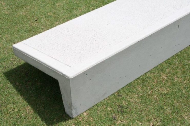 A close-up image of a sturdy concrete step and riser. The step is smooth and gray, featuring a textured surface for added grip. It has a rectangular shape with clean edges and a slightly curved front edge. The riser is positioned behind the step, providing support and stability. Both the step and riser are designed to enhance outdoor spaces, offering durability and functionality for safe and convenient access. For sale at Parklea Sand & Soil Australia.