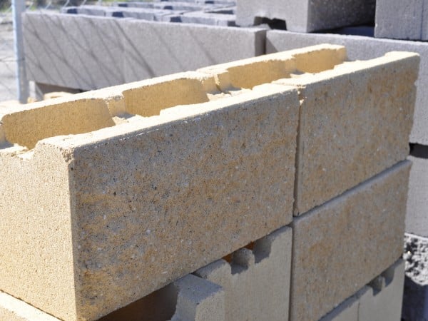 A close-up image of a split face block from the 200mm series. The block has a textured surface with a split pattern, showcasing its natural stone-like appearance. The color of the block is a warm, earthy tone, providing a rustic and modern aesthetic for construction projects. For sale at Parklea Sand & Soil Australia.