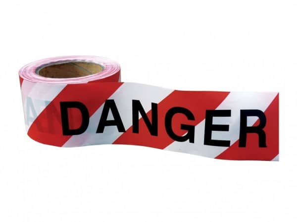 A close-up view of yellow and black barricade warning tape with bold text reading 'CAUTION' and 'DO NOT ENTER.' The tape is prominently displayed against a construction backdrop, indicating potential hazards and restricted access. The contrasting colors and clear warning messages help ensure safety in hazardous areas.