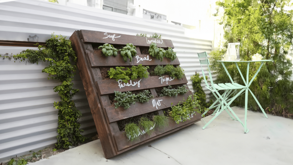 Wooden pallet repurposed into a planter, filled with plants and herbs. Recycle material landscape design by Parklea Sand & Soil. 