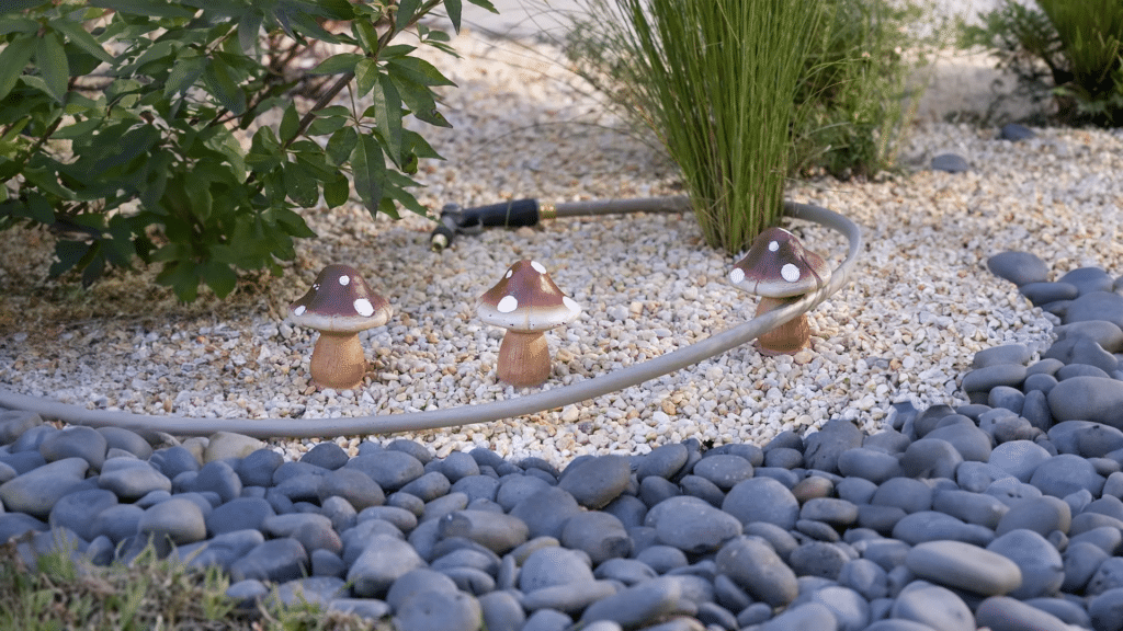 Old household decor repurposed as sculptural hose guide in the garden.