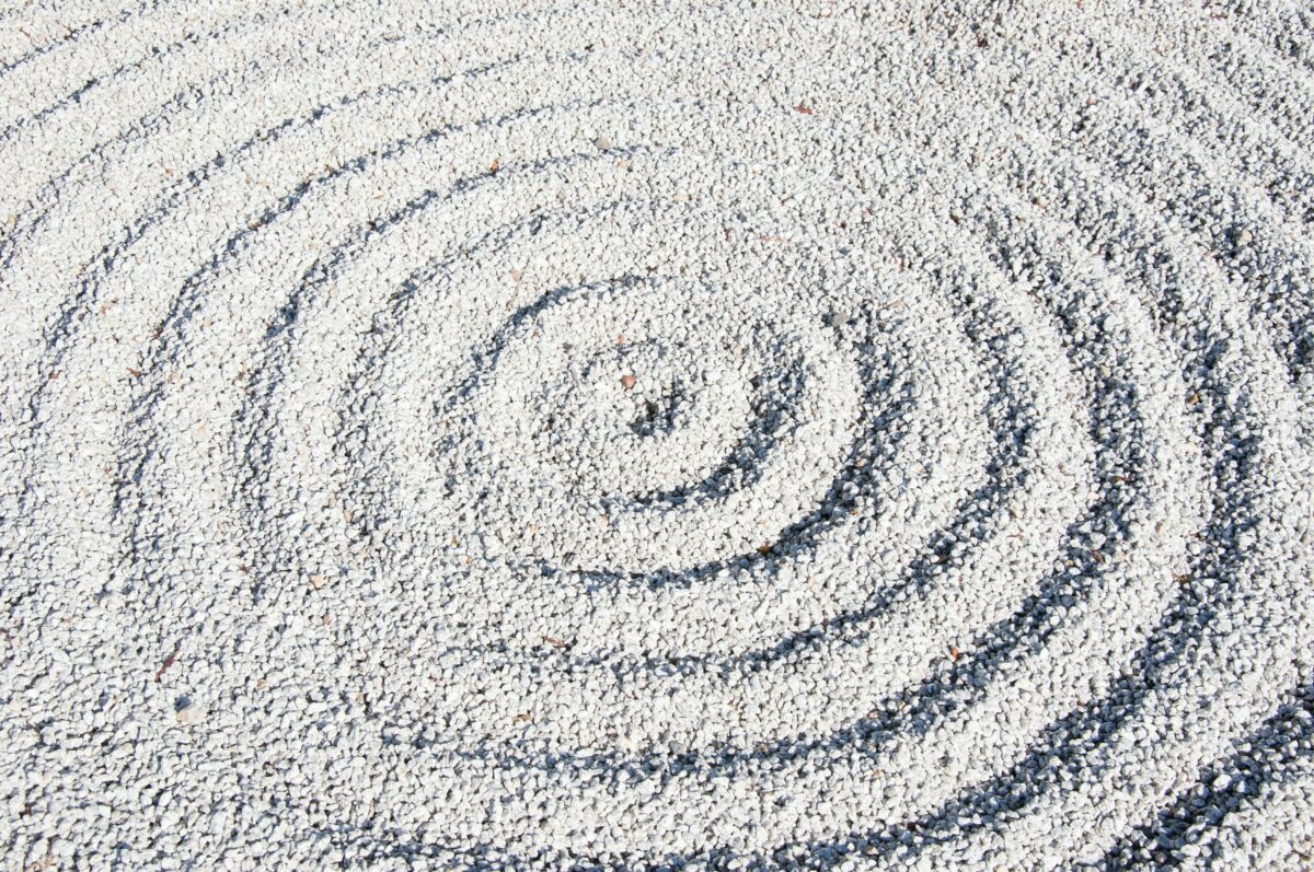 Pebbles raked in to circular shapes in a zen garden.