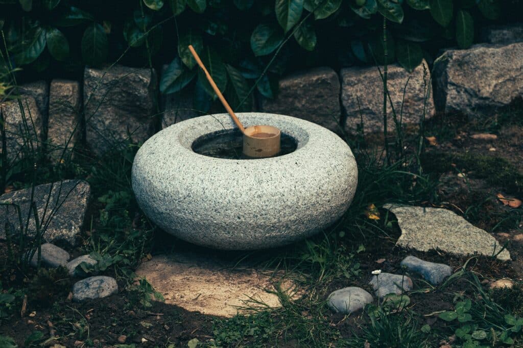 Water in grey stone bowl in a zen garden. Creating Zen Gardens in Sydney.